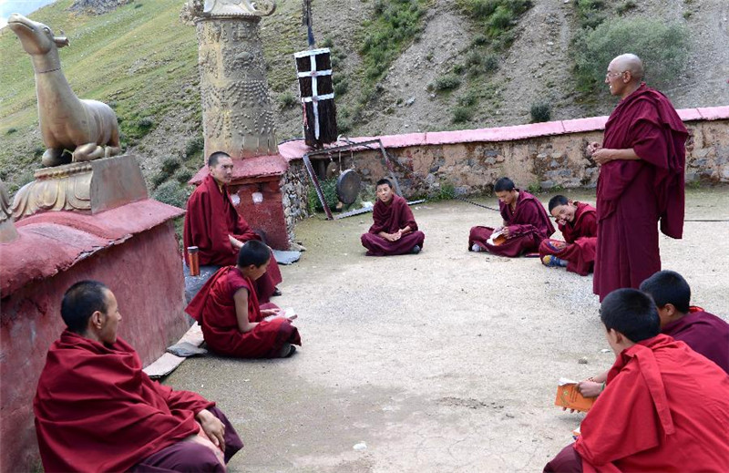 达隆寺夏仲活佛（左三）考试青年僧人学习佛学常识（8月8日摄）。