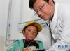 在拉萨堆龙德庆县人民医院，来自北京的援藏医生、西藏自治区第二人民医院副院长李靖为德庆乡门堆二村的7岁女孩丹增措姆看病（4月10日摄）。新华社记者 刘东君 摄