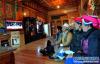 云南省迪庆藏族自治州香格里拉建塘镇红坡村的藏族老人七林农布（左二）一家人在看电视（2012年1月31日摄）。