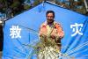 西藏日喀则吉隆县受灾群众在救灾帐篷前编织竹筐（1月3日摄）。