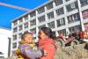 西藏日喀则吉隆县地震受灾群众次仁玉珍母子在过冬周转房前（1月3日摄）。