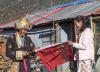 2月10日，西藏吉隆县乃村村民旺堆和女儿央金在自家房屋前准备挂国旗。新华社记者 张晓华 摄