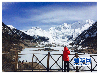 图为3月30日，一位游客在西藏波密县米堆冰川前的融湖边拍摄。（新华网 达娃摄）