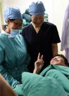 4月22日，患严重心脏缺损的先心病患儿桑美向刚为他完成手术的北京安贞医院小儿心脏内科医生打出胜利手势。 