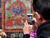 4月27日，观众在观摩记录丹巴绕旦大师绘制的唐卡作品。