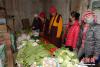 来自多仓寺的僧人乌金扎西（右三）每周都会驱车两百多公里，到约改镇集贸市场为寺院采购新鲜水果蔬菜。 胡贵龙 摄