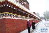 5月26日，在甘肃甘南藏族自治州合作市，藏族群众围着雪后的米拉日巴佛阁转经。