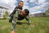 5月26日，在西藏公安边防总队营区，小涛涛趴在父亲身上一起做俯卧撑。