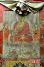 6月11日，展览中的丝质彩绘勉拉顿珠真迹藏文款释迦牟尼师徒三尊唐卡。