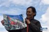 女登山家桂桑展示41年前在海拔8200米的珠峰营地入党时的照片(6月1日摄)。 