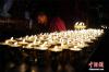 7月26日，一名喇嘛在松赞林寺内准备酥油灯。松赞林寺是云南最大的藏传佛教寺庙群落，还是滇西北一带的黄教中心，被誉为“小布达拉宫”。 中新社记者 侯宇 摄
