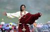 7月26日，一名藏族青年在巴塘草原上展示传统服饰。