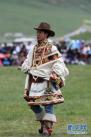 7月26日，一名藏族男子在巴塘草原上展示传统服饰。
