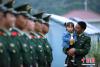 图为武警西藏边防总队吉隆边防检查站司令部勤务中队中队长张振兴带着自己的妻子和女儿观看队列训练。 通讯员 吉隆 摄