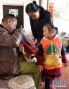 父母帮助其美拉姆整理书包，准备去幼儿园（10月6日摄）。
