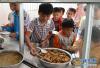 广西大化瑶族自治县大化镇仁良小学学生在领营养午餐（4月21日摄）。新华社记者 陆波岸 摄