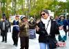 图为10月19日，拉萨市布达拉宫脚下的宗角禄康公园内，外国游客与市民一起跳起锅庄舞。李林 摄