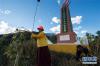 10月18日，顶果山寺活佛丹贝降参（左）和当地藏族群众清理顶果山格勒得沙革命烈士纪念碑附近的杂乱植物。