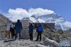 10月29日，游客在珠穆朗玛峰大本营的石碑前拍照。