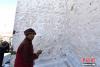 11月3日，一名僧人正在粉刷大昭寺外墙。