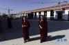 两名僧人从青海省藏语系佛学院的食堂前经过（11月16日摄）。
