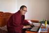 来自青海省果洛藏族自治州甘德县的僧人更尕宋日在宿舍用电脑学习经文（11月16日摄）。