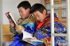 11月24日，在甘肃省天祝县抓喜秀龙乡代乾教学点，8岁的二年级学生闫尕藏才旦（前）和7岁的一年级学生贾吉雄在宿舍里看书。