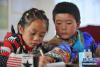 11月24日，在甘肃省天祝县抓喜秀龙乡代乾教学点，7岁的一年级学生索南卓玛（左）和贾吉雄在自习课上学习。