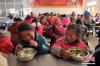 学校食堂开心吃饭的孩子们。 中新社记者 刘忠俊 摄