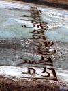 当地牧民在结冰的通天河上用沙子写下的祝福语。新华网 更青 摄