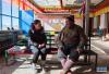 贡曲（左）向60岁的堆瓦村村民索朗扎西了解情况（2月9日摄）。 