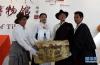 这是蒙古族姑娘格日勒(左二)向西藏牦牛博物馆捐赠牦牛皮制作的老皮箱。 