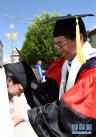 6月6日，西藏藏医学院博士、硕士生导师央美(右)在毕业典礼上给硕士毕业生献哈达。新华社记者 觉果 摄