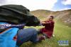 6月15日，在青海省海北藏族自治州祁连县野牛沟乡，两名当地群众进行蹬棍比赛。蹬棍是青藏高原藏族民间流行的独具一格的体育运动项目。比赛一般为两人，参赛双方坐在草地上四足相抵，两方双手共握一根木棒，以将对手拉离地面为胜，是锻炼腰部力量的有效方法。新华社记者 吴刚 摄