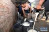7月20日，在甘南藏族自治州燎原乳业有限责任公司多河村收奶站，牧民将鲜牦牛奶倒入桶中准备过称。陈晔华 摄