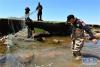 刚察县海滨藏城应急救援队的队员们准备打捞搁浅的湟鱼（6月22日摄）。新华社记者 王博 摄