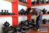 9月12日，25岁的拉茸肖巴在汤堆村黑陶技艺展览区整理待出售的藏族黑陶。 新华社记者 井辉辉 摄