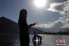 9月12日晚，藏族女孩在拉萨河畔梳理秀发。中新社记者 孙翔 摄