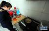 9月25日，值班员田莉在变电所小食堂内做饭。新华社记者侯德强摄