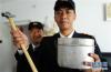 9月27日，儿子张海洋（右）在展示他和父亲工作上必备的铝制饭盒和检车锤。新华社记者 侯德强摄
