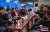 在林芝市米林县派镇加拉村，临时安置点内的村民围坐一起祝福工布新年(11月19日摄)。