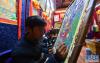 拉萨八廓街附近临街一间唐卡商铺内，画师在绘制唐卡（11月29日摄）。新华社记者 晋美多吉摄