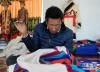 西藏日喀则市谢通门县塔定乡贫困群众占堆在专业合作社里缝制藏袍(12月8日摄)。