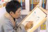 北京对口支援地区特色产品展销会上，唐卡画师赤增绕旦正在绘制唐卡。西藏在线网 马阳阳 摄