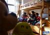 12月24日，在西藏自治区福利院的宿舍里，大孩子在给弟弟们读故事。新华社记者 晋美多吉 摄