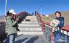 次卓玛在岗巴拉山观景台为客人拍照(1月14日摄)。新华社记者 张汝锋 摄