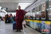 图为拉萨站，一名僧人即将上车。中新社记者 何蓬磊 摄