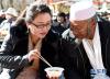 2月8日，拉萨市藏热社区的一名藏族妇女给回族大叔介绍藏式“古突”。新华社记者觉果摄
