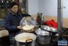 2月14日，在西藏拉萨市城关区夺底乡维巴村的一处藏式民宿中，女主人德吉的母亲正在煮“古突”夜面疙瘩汤。新华社发（格桑边觉 摄）