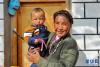 普玛江塘乡萨藏村52岁的村民拉巴平托抱着孙子在自家阳光房里晒太阳(1月14日摄)。新华社记者 张汝锋 摄